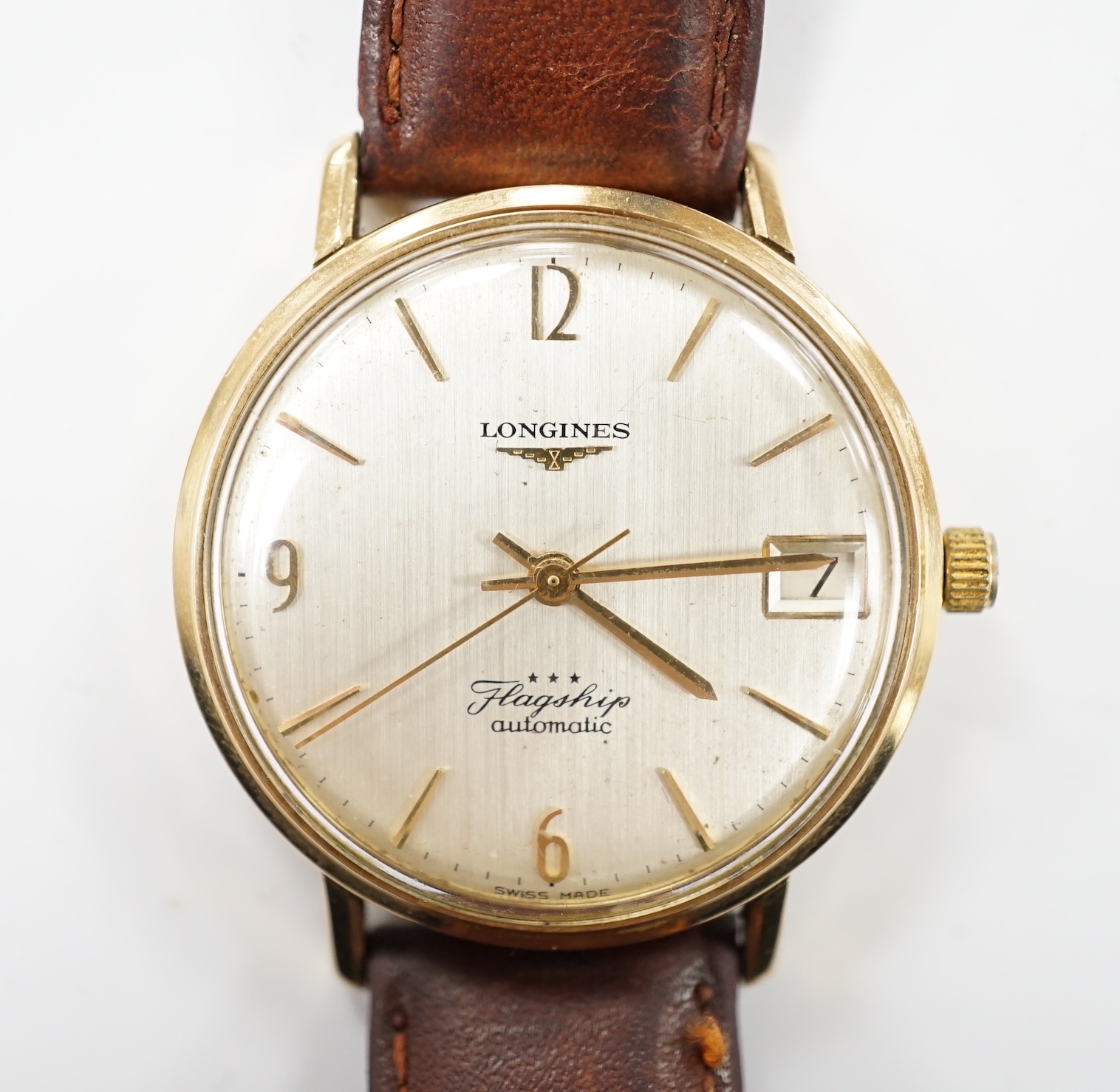 A gentleman's 9ct gold Longines Flagship automatic wrist watch, with baton numerals and date aperture, on associated leather strap.